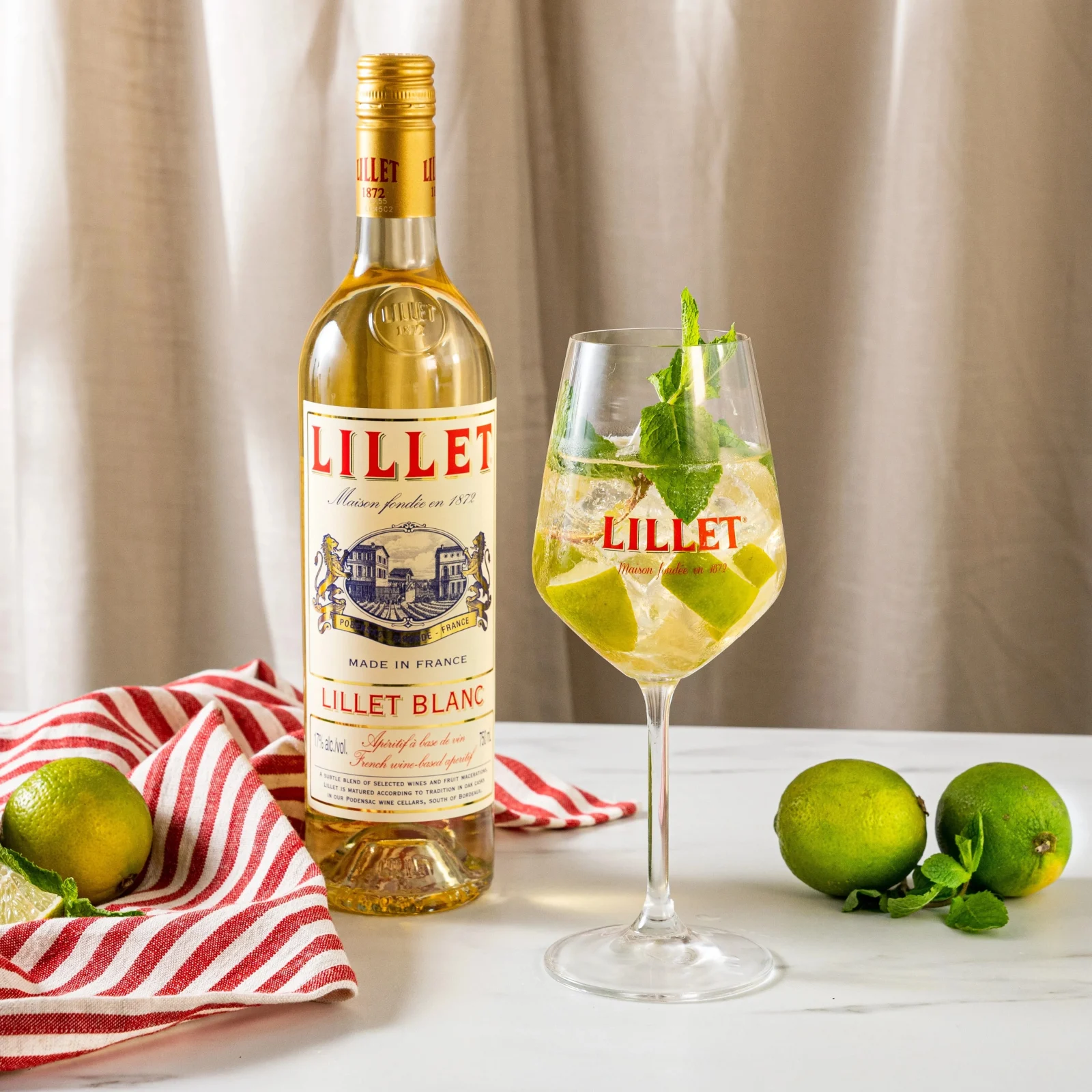 Lillet Hugo Spritz a refreshing twist of summer with lime wedges and mint leaves